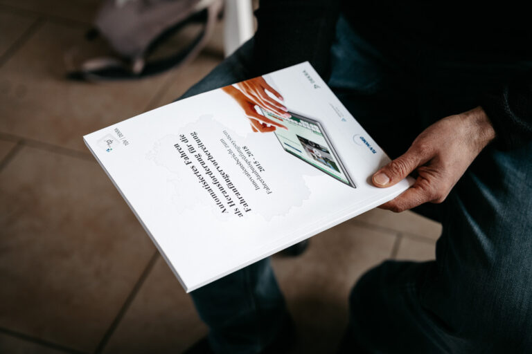 Jan hält eine Broschüre in der Hand vom TÜV
